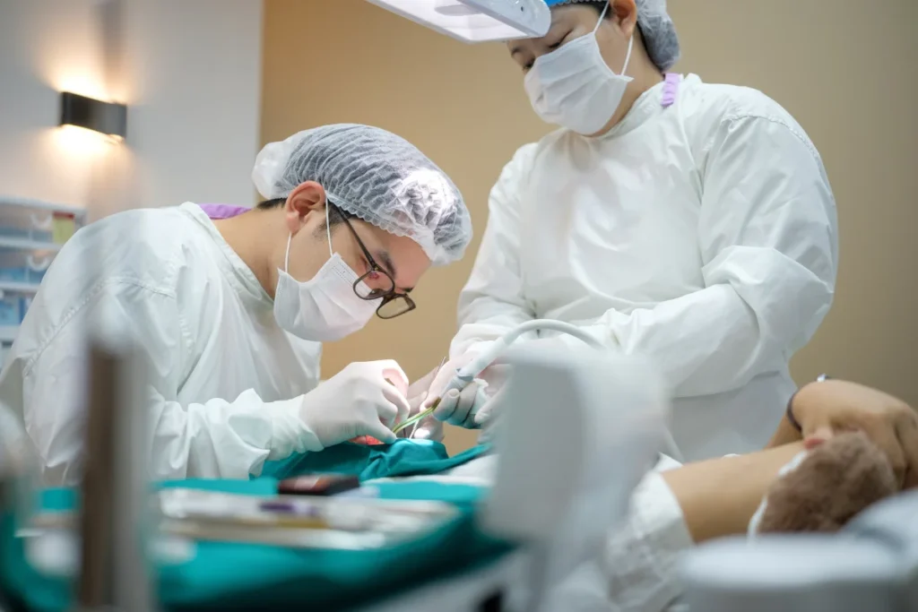 Dentist assistant performing oral procedure on patient in clinic ahead of dental implant surgery